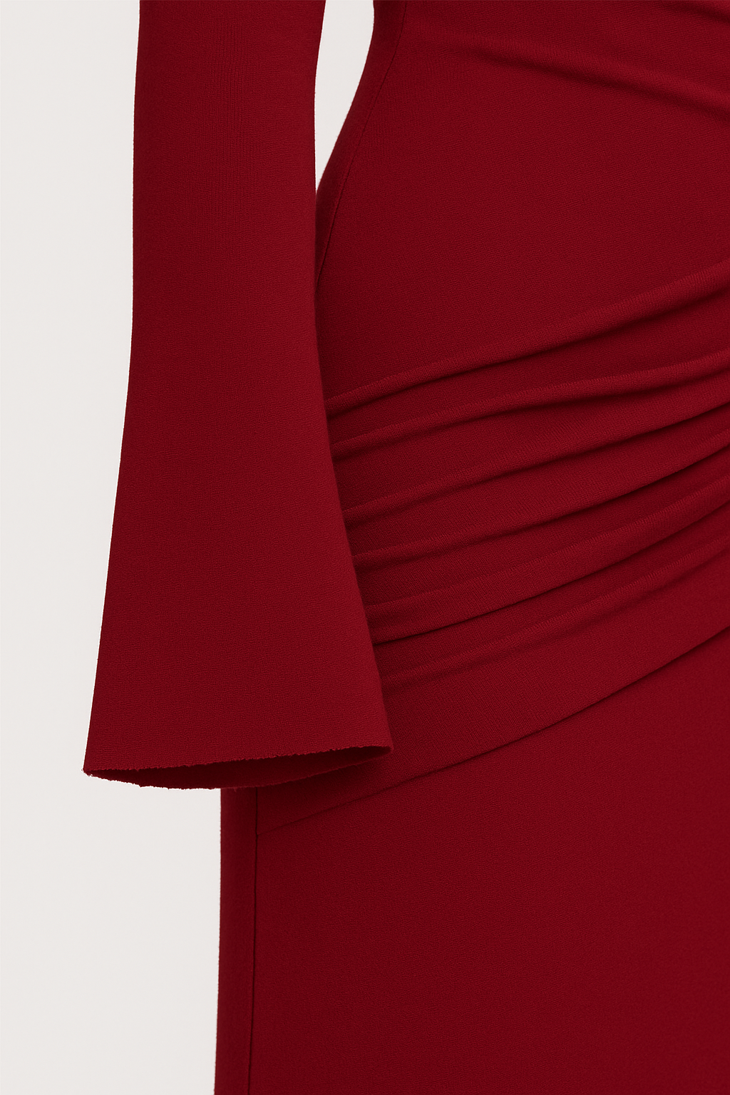 Close-up of a red dress with a draped design on a white background